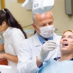 Dentist doing procedure on young patient woman